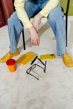 Woman Sitting with Dropped Notebook Smartphone and Glasses on Floor