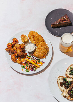 Delicious vegan fish and chips with side of potato and dishes