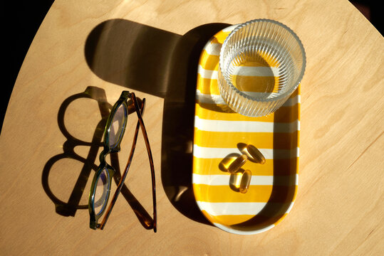 Glasses and medicine on a table with a glass of water