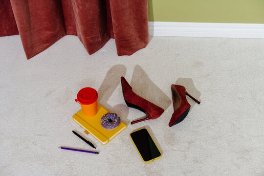 Red High Heels with Coffee Cup, Donut and Notebook on Carpet 