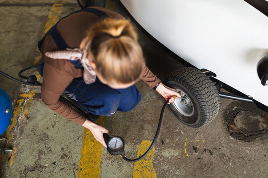 Female Mechanic Checking Tire Pressure for Hot Rod Rental Fleet