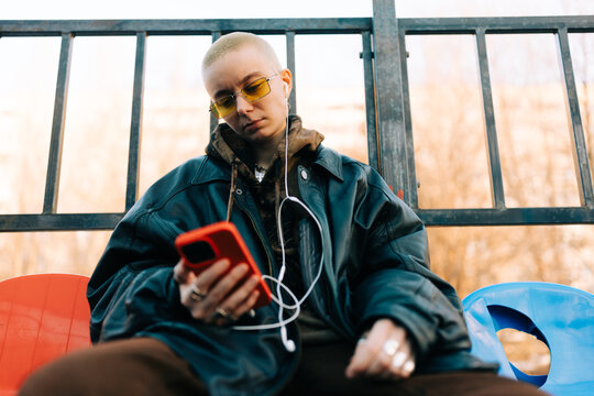 Person Listens to Music While Sitting on a Bench Outside