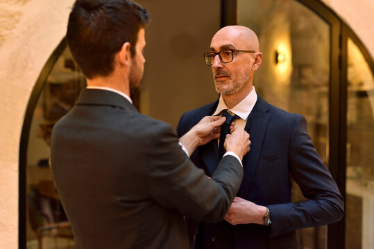 Men at home getting ready, adjusting bow tie before night out