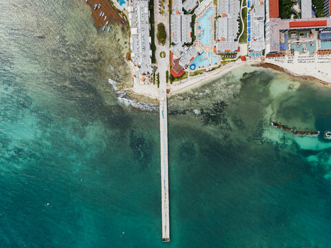 Aerial top view of pier and resort coastline
