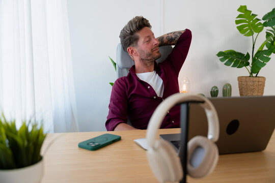 Man Relaxing with Hands Behind Head at Desk