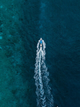 Aerial view of speedboat leaving wake in deep blue sea
