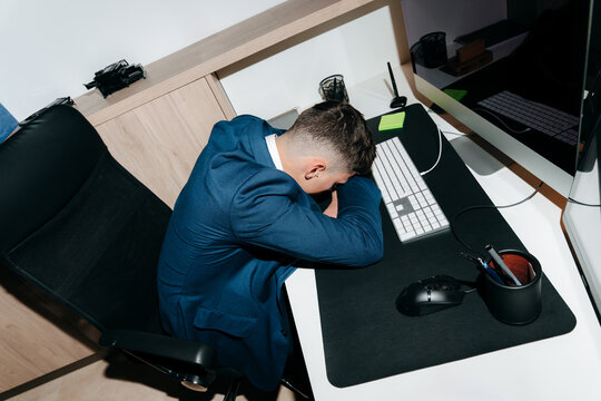 Young Employee With Burnout Resting on Desk At The Office