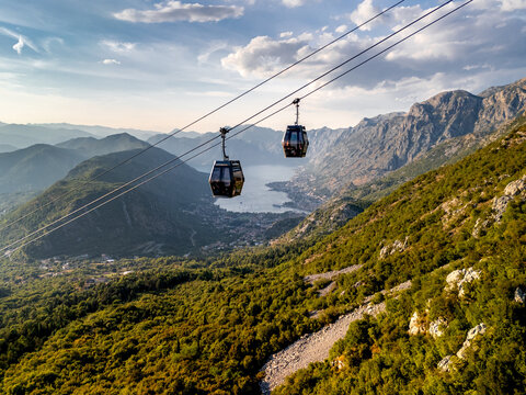 Cable Cars Travel Over Mountains in Kotor Bay During Sunset Hours