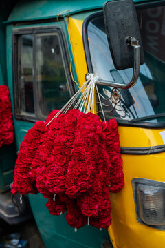 Red flower garlands hanging on an auto rickshaw