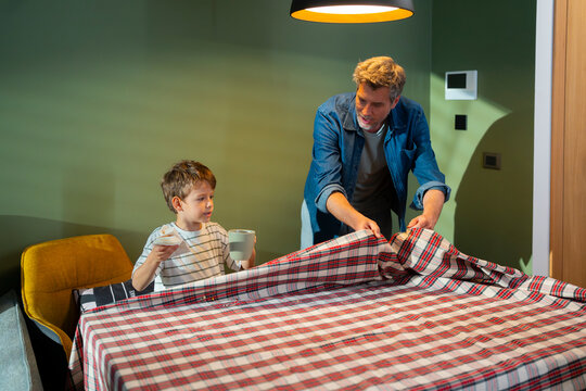 Father and son prepare a table together at home