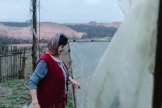Woman entering greenhouse in rural yard