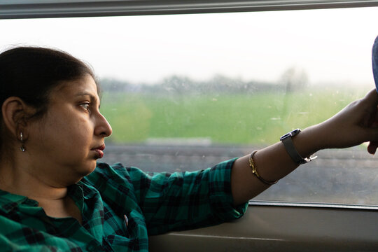 Indian woman enjoying train ride in late evening