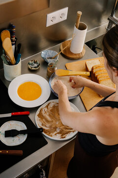 Lady calmly assembling traditional Spanish torrijas in a quiet morning