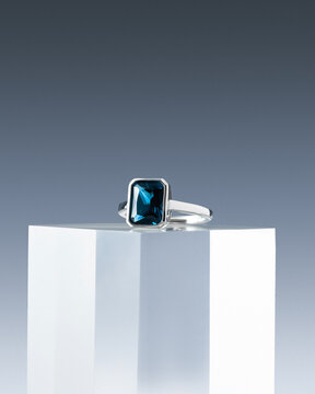 Iridescent Blue Gem Ring on Illuminated Glass Stand Macro