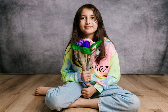 Young girl holding bouquet of artificial flowers