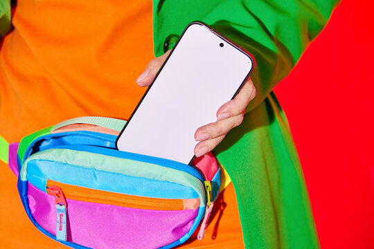Person Pulling Smartphone from Colorful Waist Bag. Blank, mock-up. 