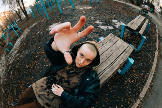Person Sits on Bench in Park and Reaches out With Hand