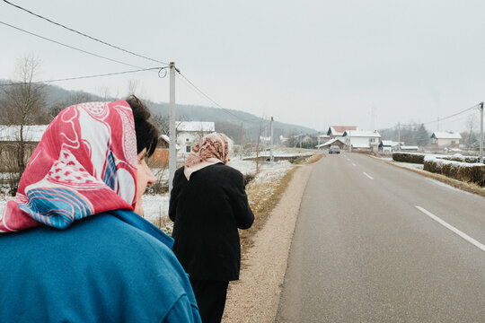 Elderly women walking along village road in winter