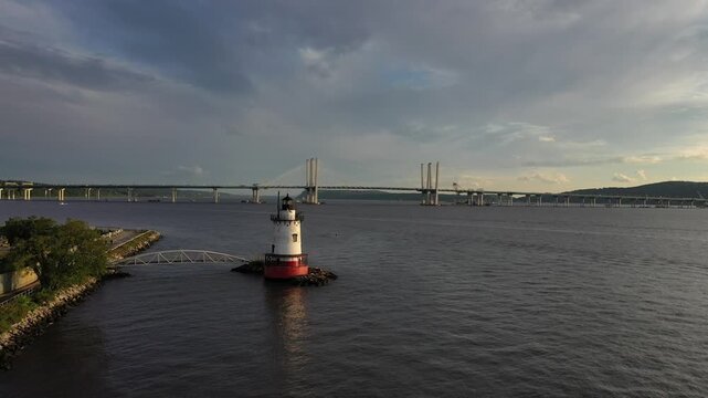 Aerial view of Sleepy Hollow Lighthouse on the Hudson River with the Governor Mario M. Cuomo Bridge in the background under a cloudy sky Sleepy Hollow, New York, United States.
