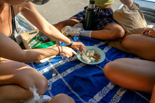 UGC Anonymous women sharing snacks in car trunk at parking lot