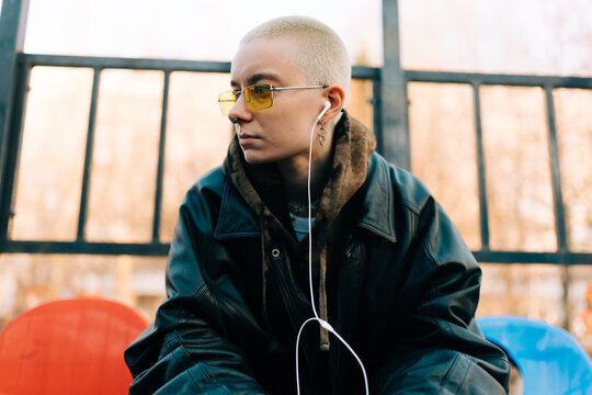 Person With Short Hair Listens to Music Outside on a Sunny Day