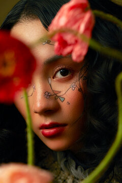 Portraits of women with floral-themed makeup, and flowers