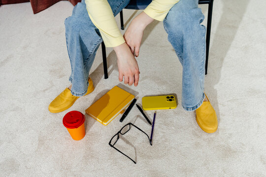 Person Dropping Personal Items While Sitting on Chair Indoors