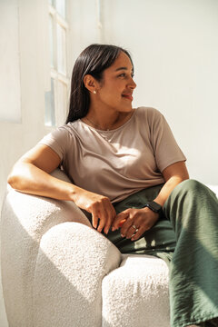 Relaxed Casual Woman Portrait Sitting in Sunlit Modern Sofa