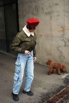 Person walks a dog in a city street