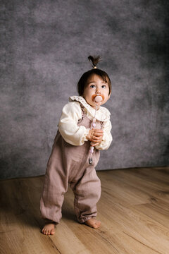 Baby girl exploring studio with pacifier