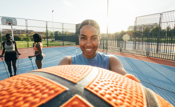 Woman enjoying basketball on sunny outdoor court