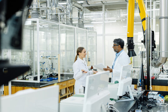 Two scientists young woman and Indian man in real laboratory