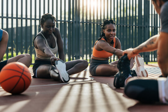 Group stretches on outdoor basketball court