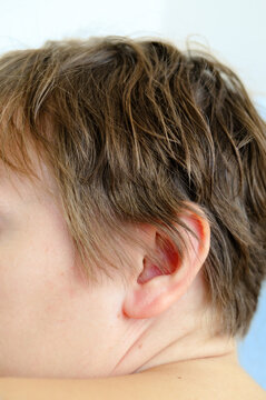 Close up detail of woman&rsquo;s ear and short hair in soft natural light