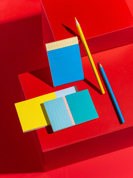 Vibrant stationery set with colorful sticky notes and pencils on red