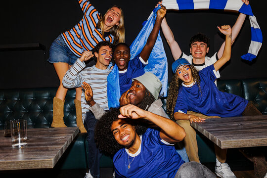 Diverse group of enthusiastic sports fans cheering victory