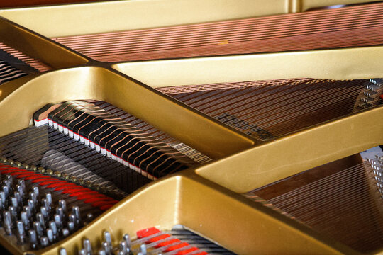 Side view over the strings of an opened classical grand piano