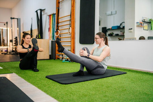Women training with personal trainer in functional gym