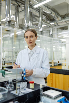 Young female lab assistant portrait in real laboratory setting