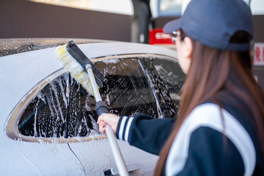 washing a car with brush and soap foam for detailing service