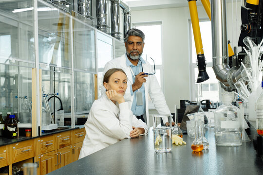 Two scientists young woman and Indian man in real laboratory