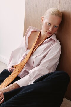 Portrait woman in tie and shirt sit indoors