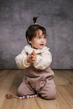 Happy baby girl clapping hands in studio