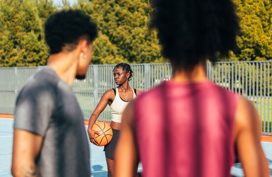 Basketball player holding ball on outdoor court