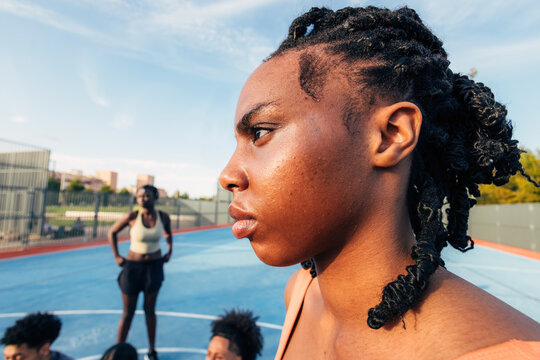 Focused black athlete preparing on outdoor basketball court