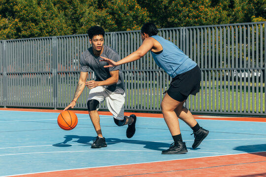 Intense outdoor basketball game on a sunny court