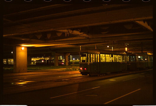 Tram under overpass at night