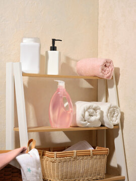 Bathroom shelf displaying the bottles, toiletries and rolled towels