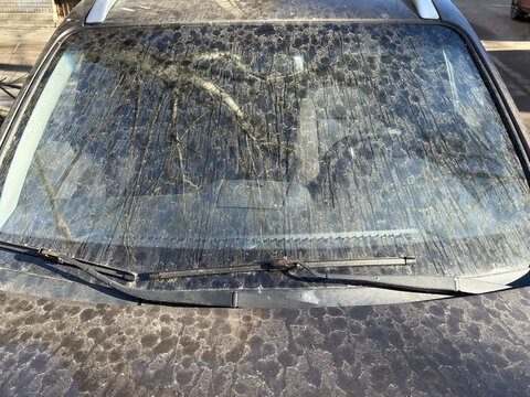 Windshield shows dirt and dust on a parked car
