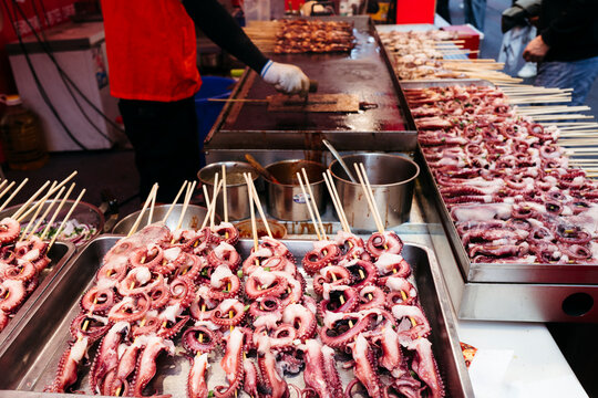 Delicious Street Food Scene Showcasing Octopus Skewers Grilling
